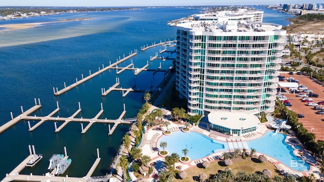 aerial view of a nearby body of water, apartment complex / building, and a pool