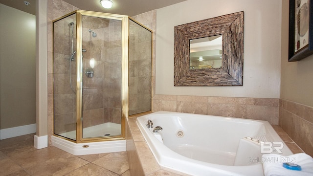 bathroom with a shower stall, a jetted tub, and tile patterned floors