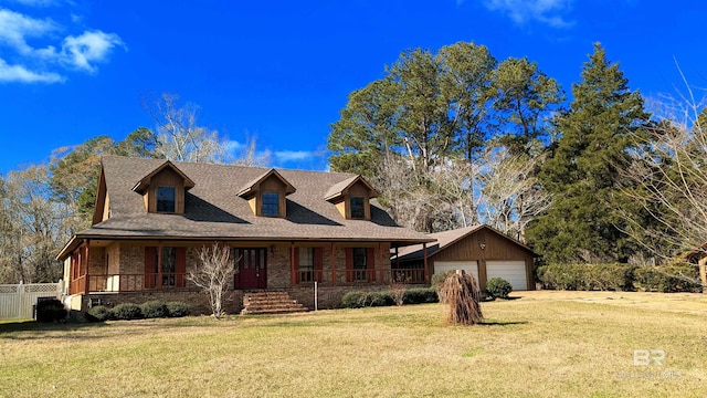 view of front facade featuring an outbuilding, covered porch, a front yard, and a garage