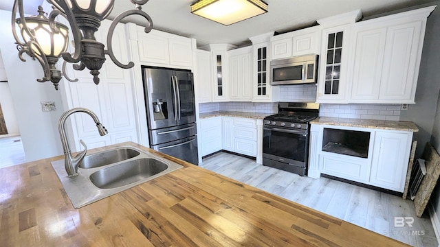 kitchen featuring white cabinets, sink, stainless steel appliances, and light hardwood / wood-style flooring