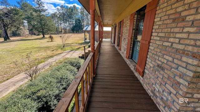 deck featuring a yard and covered porch