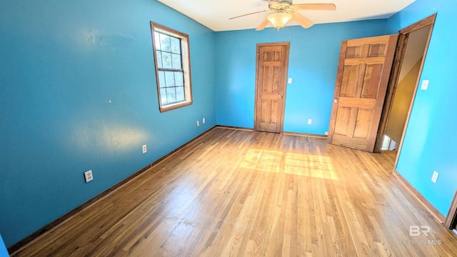 empty room with ceiling fan and light hardwood / wood-style floors