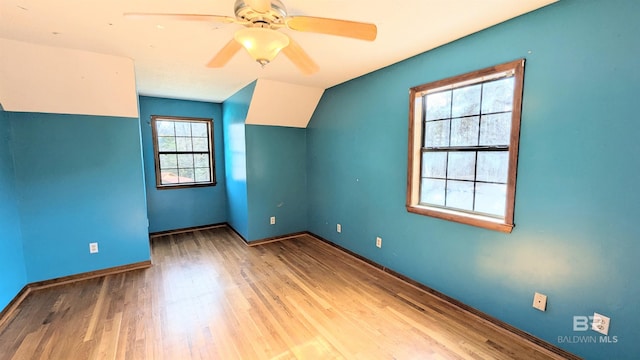 empty room featuring ceiling fan, vaulted ceiling, and hardwood / wood-style flooring