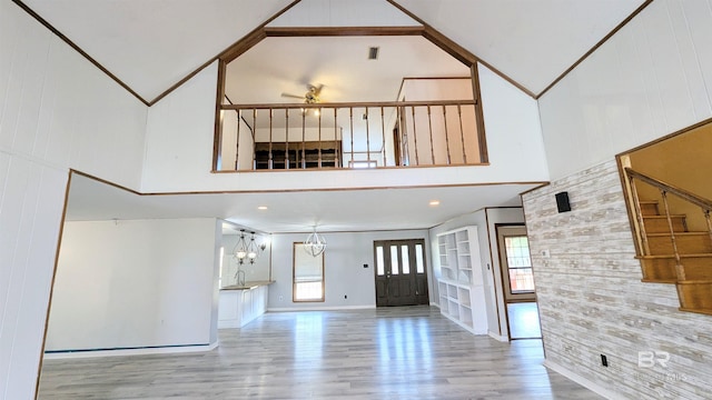 interior space featuring a high ceiling, light wood-type flooring, a notable chandelier, and sink