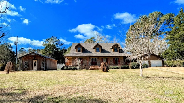 view of front of house with a front yard, a garage, a storage shed, and covered porch