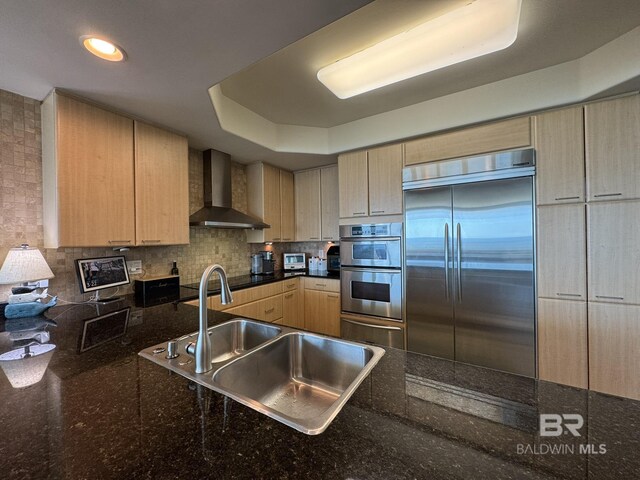 28107 Perdido Beach Blvd Unit D713, Orange Beach, AL 36561 - kitchen with appliances with stainless steel finishes, light brown cabinets, a sink, wall chimney range hood, and backsplash