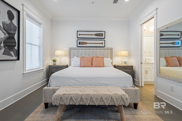 bedroom with hardwood / wood-style flooring, ensuite bath, and ornamental molding