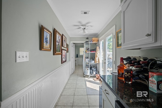 hall with crown molding and light tile patterned floors