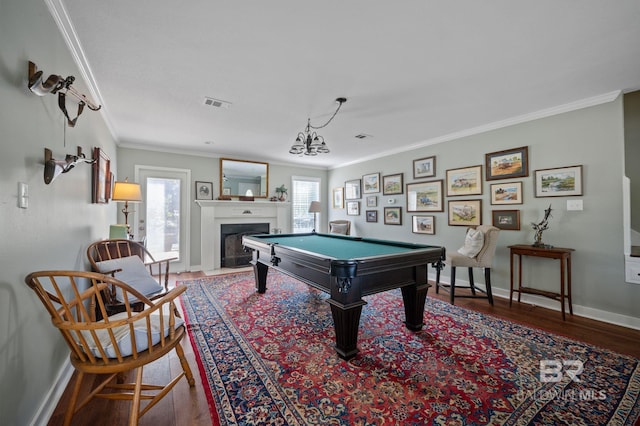 rec room with a notable chandelier, wood-type flooring, ornamental molding, and billiards