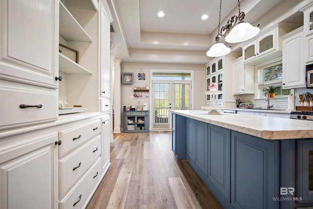 10197 Bellingrath Rd, Theodore, AL 36582 - kitchen with open shelves, blue cabinetry, white cabinetry, light wood-style floors, and stainless steel microwave