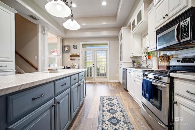 10197 Bellingrath Rd, Theodore, AL 36582 - kitchen with stainless steel appliances, white cabinetry, a raised ceiling, gray cabinets, and backsplash