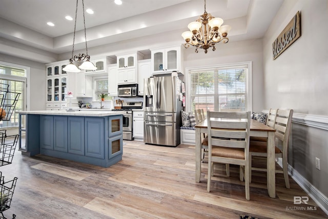10197 Bellingrath Rd, Theodore, AL 36582 - kitchen with stainless steel appliances, white cabinets, light wood finished floors, a chandelier, and recessed lighting