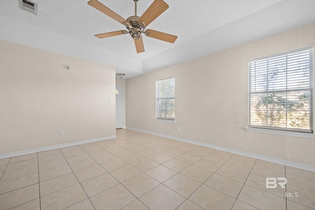 tiled spare room with a textured ceiling and ceiling fan