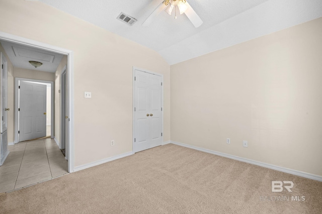 unfurnished bedroom featuring a textured ceiling, light colored carpet, ceiling fan, and lofted ceiling