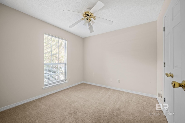 carpeted spare room featuring ceiling fan and a textured ceiling