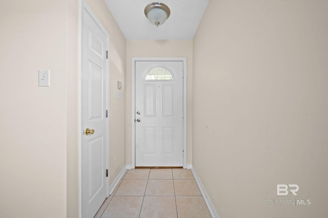 doorway featuring light tile patterned floors and a textured ceiling