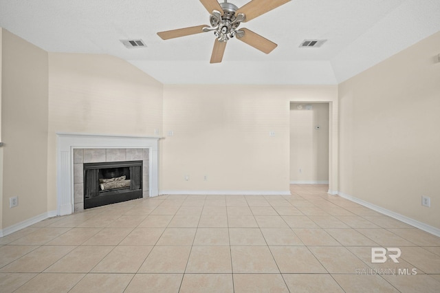 unfurnished living room with ceiling fan, lofted ceiling, light tile patterned floors, and a tiled fireplace