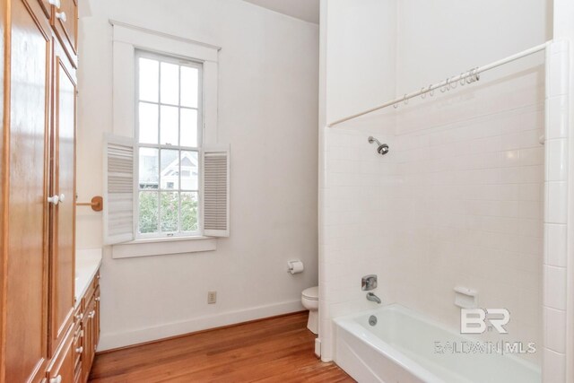 full bathroom with vanity, wood-type flooring, washtub / shower combination, and toilet