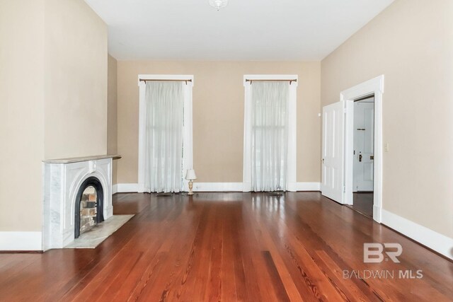 unfurnished living room featuring wood-type flooring and a fireplace