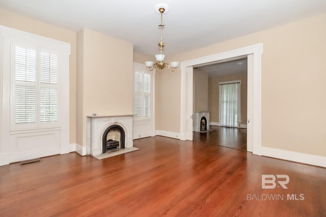 unfurnished living room with wood-type flooring and a chandelier