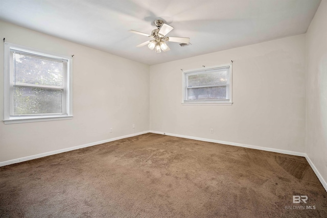 carpeted spare room featuring ceiling fan