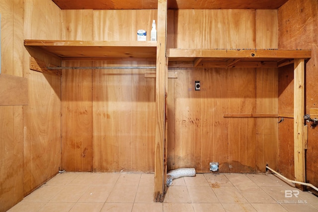 laundry area with wooden walls, tile patterned flooring, and hookup for an electric dryer