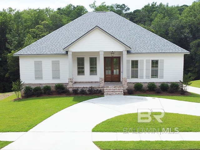 view of front of property featuring a front lawn, covered porch, and french doors