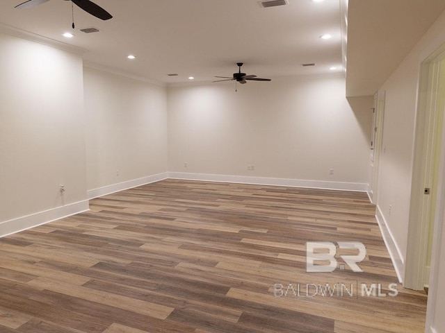 empty room featuring ceiling fan, hardwood / wood-style floors, and ornamental molding