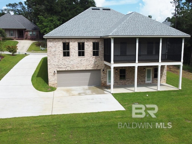 view of front of property with a front yard, a garage, and a sunroom