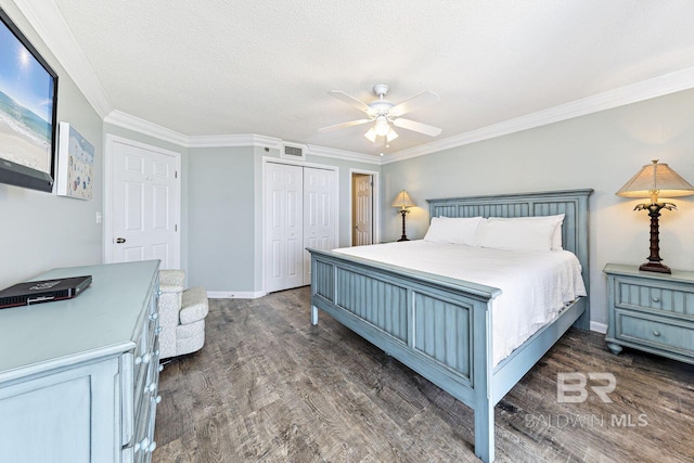 bedroom featuring visible vents, ornamental molding, wood finished floors, and a closet