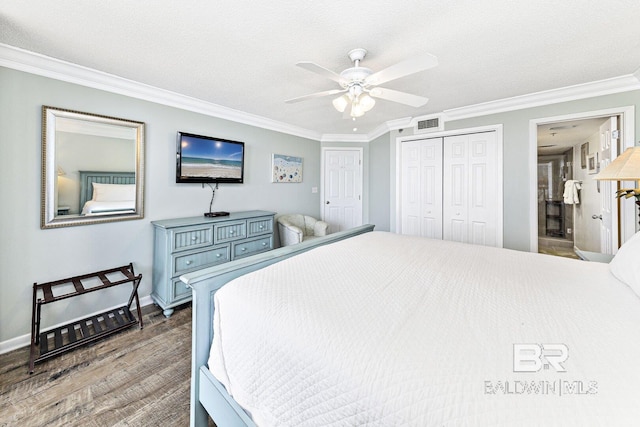 bedroom featuring baseboards, wood finished floors, visible vents, ornamental molding, and a closet