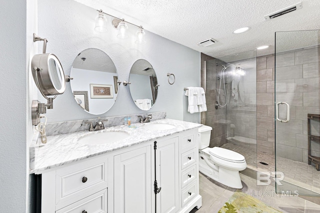 bathroom featuring a textured ceiling, visible vents, and a sink