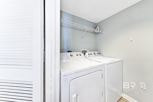 laundry room with laundry area, baseboards, and washer and dryer