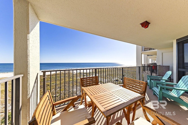 balcony featuring a water view and a view of the beach