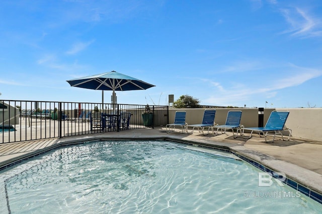 view of swimming pool featuring a patio area and fence