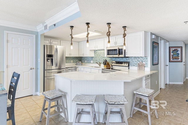 kitchen with visible vents, a peninsula, a textured ceiling, a sink, and stainless steel appliances