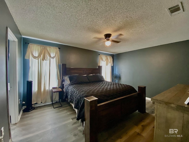 bedroom featuring a textured ceiling, hardwood / wood-style flooring, and ceiling fan