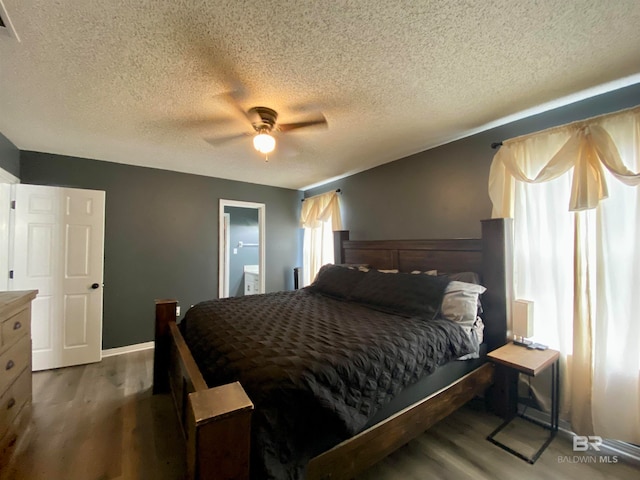 bedroom featuring a textured ceiling, ceiling fan, hardwood / wood-style floors, and connected bathroom