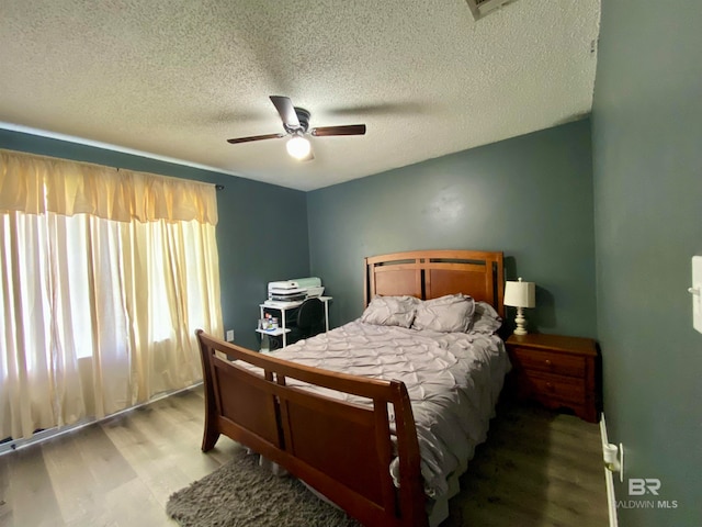 bedroom featuring wood-type flooring, a textured ceiling, and ceiling fan