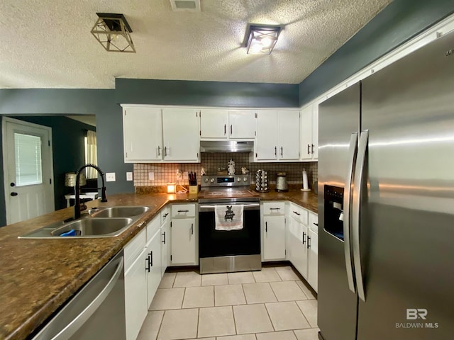 kitchen featuring appliances with stainless steel finishes, decorative backsplash, white cabinetry, and sink