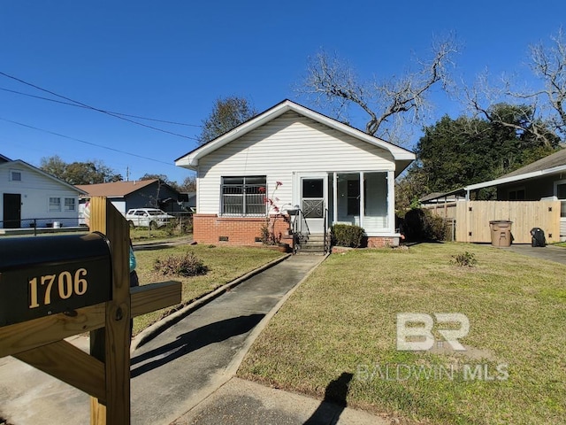 bungalow-style home featuring entry steps, crawl space, a front yard, and fence