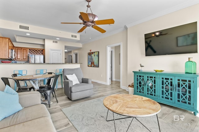 living room featuring ceiling fan, light hardwood / wood-style flooring, and ornamental molding