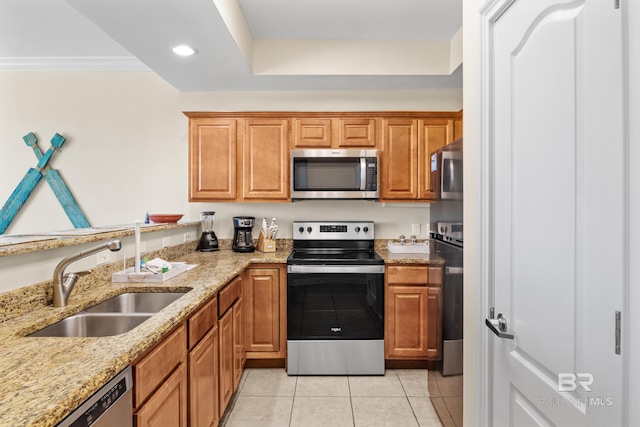 kitchen with light stone counters, sink, light tile patterned flooring, and stainless steel appliances