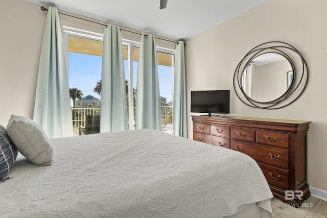 bedroom with access to exterior, light wood-type flooring, and ceiling fan