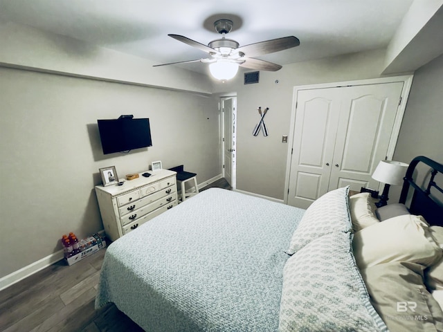 bedroom featuring a closet, dark hardwood / wood-style floors, and ceiling fan