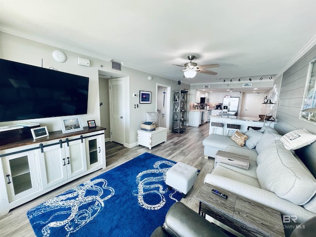 living room with hardwood / wood-style flooring, crown molding, ceiling fan, and track lighting