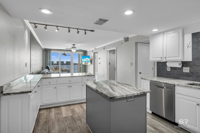 kitchen with white cabinetry, kitchen peninsula, light wood-type flooring, a kitchen island, and stainless steel dishwasher