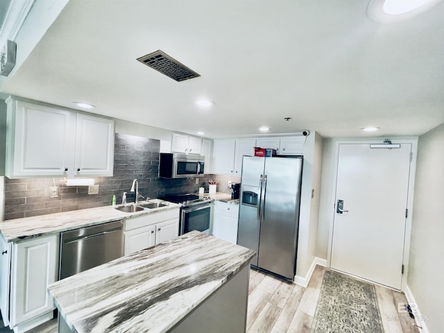 kitchen with appliances with stainless steel finishes, sink, and white cabinetry