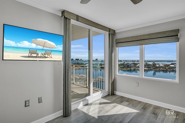 unfurnished sunroom featuring ceiling fan and a water view