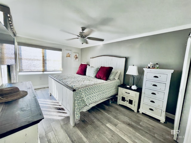 bedroom featuring hardwood / wood-style flooring, crown molding, and ceiling fan